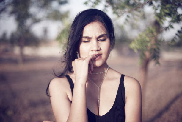 Indian Asian young female close up portraits of pensive emotion facial gesture mood feeling in outdoors daylight stock photo