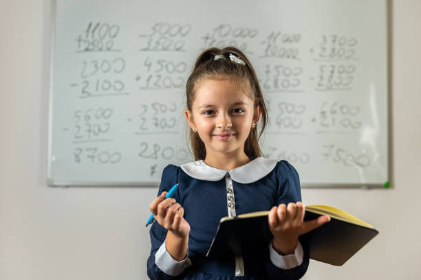 istock fleeting student stands by the blackboard with her notebook to see where to take an example. 1477756662