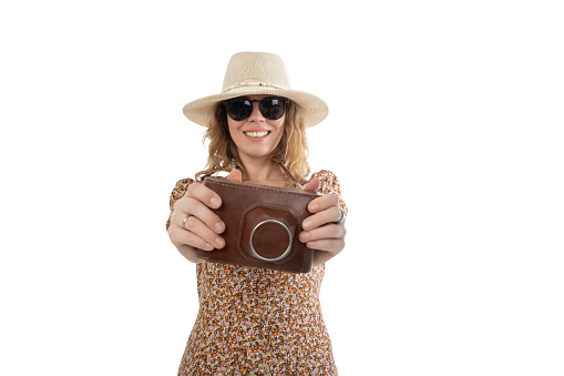 Woman in sunglasses, brown dress in hat with retro camera isolated on white background.