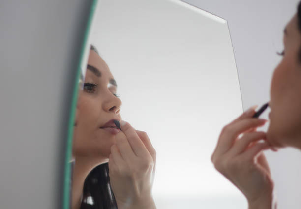 istock Black haired young woman is doing make up. 1477756784