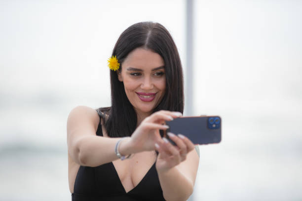 istock Young woman is taking a selfie at the sea side. 1477757945