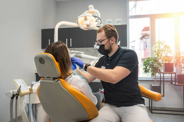 istock dentist examines a patient's teeth in a modern dental office. Close up. 1477759473