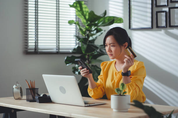 istock Asian woman holding credit card using smartphone have a problem with shopping and paying online. 1477759997