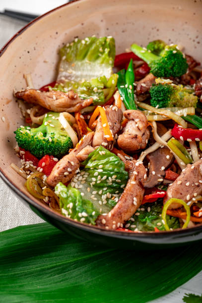 Udon stir fry noodles with pork meat and vegetables in a plate on white wooden background. Udon stir fry noodles with pork meat and vegetables in a plate on white wooden background. Asian cuisine. Delicious and healthy food. Photo for the menu. teriyaki stock pictures, royalty-free photos & images