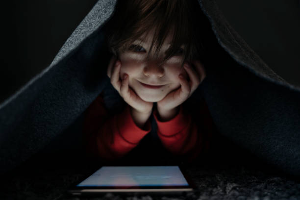 istock Little boy on rug and playing at a digital tablet 1477765215