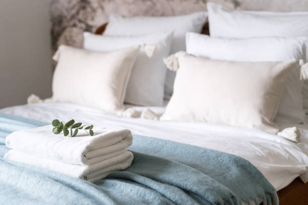 istock fresh terry towels prepared on bed with cushions and bedding 1477765560