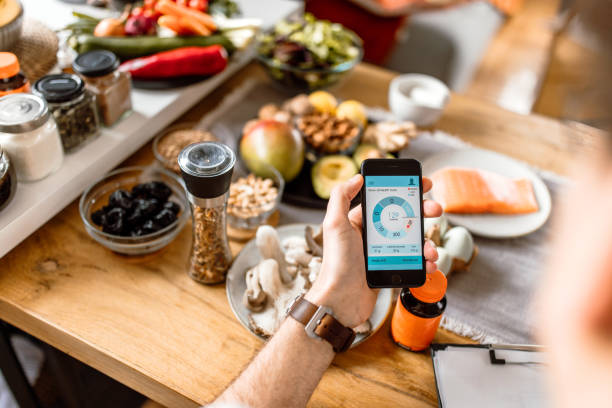 istock Young man tracking food intake with mobile app at home 1477767241