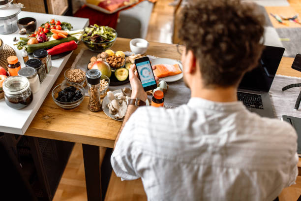 Young man tracking food intake with mobile app at home