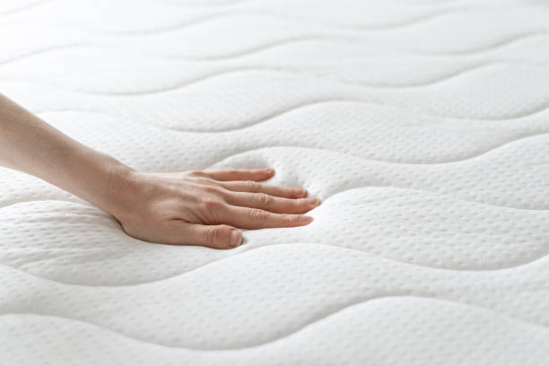 woman press on comfortable mattress and checking quality cropped shot of female hand testing new white orthopedic mattress on firmness in furniture store, memory foam surface, closeup push pause stock pictures, royalty-free photos & images