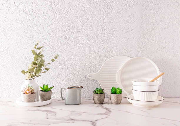 istock white ceramic utensils and indoor flowers in ceramic mini pots on the kitchen countertop made of white marble. grey cement wall. a copy space. 1477767789