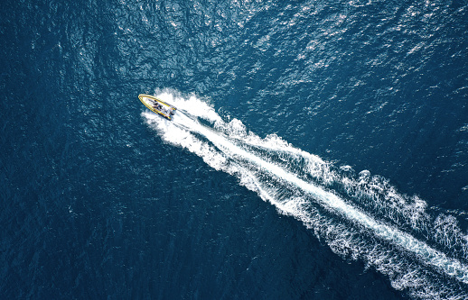 Aerial view of luxury yacht moving fast at Adriatic sea during sunny day.