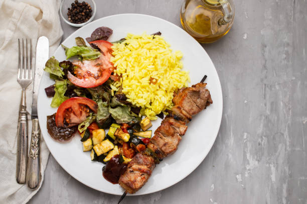 istock Grilled meat on stick, vegetables, salad and boiled rice 1477776279