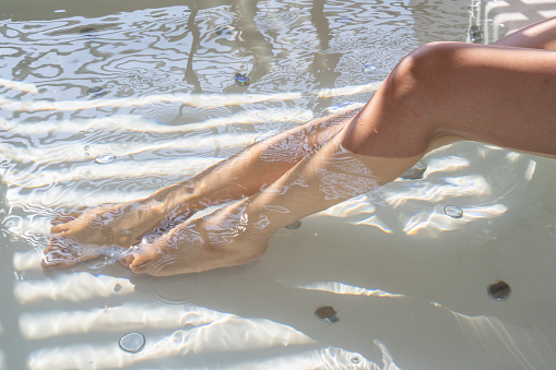Close up legs of a woman while relaxing and enjoy taking a bath in the hot tub