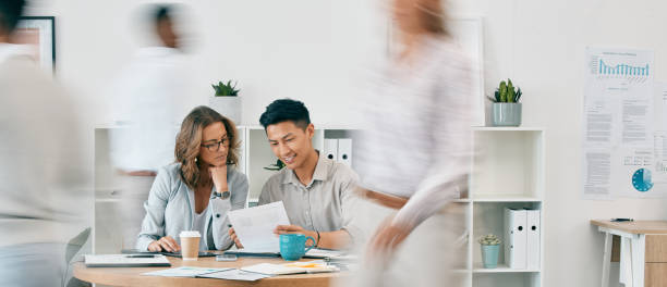 istock Teamwork, documents and business people in office for review or discussion. Paperwork, collaboration or Asian man and woman at desk in busy workplace planning sales, advertising or marketing strategy 1477780395