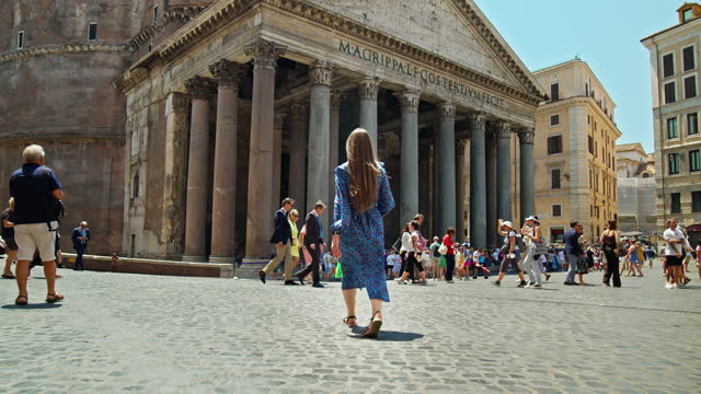 A young woman walking towards Pantheon Monument in the center of Rome.