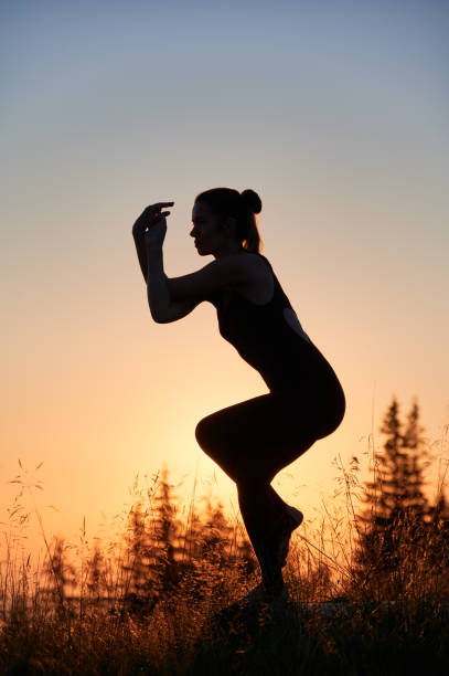 istock Elegant silhouette of girl doing eagle pose. 1477787505
