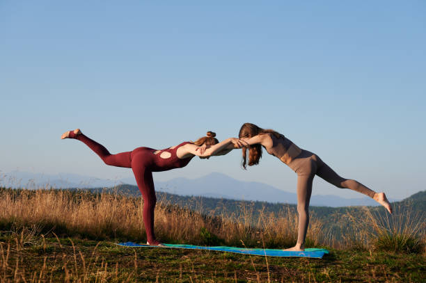 istock Two girls doing yoga pose at early morning. 1477787547