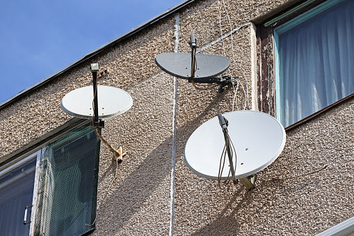 Parabolic antennas on the wall of an apartment building
