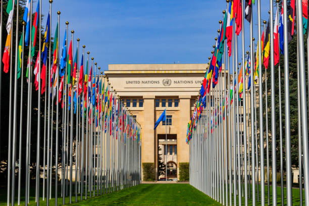 Rows of the United Nations member states flags in a front of Palace of United Nations in Geneva, Switzerland stock photo