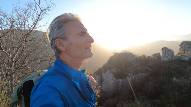 istock Mature male hiker arrives at summit viewpoint in hilly setting 1477791002