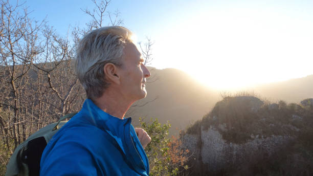 istock Mature male hiker arrives at summit viewpoint in hilly setting 1477791004