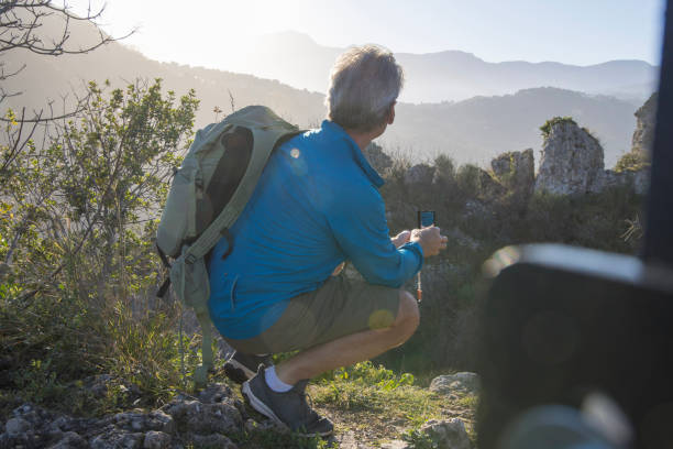 istock Mature male hiker arrives at summit viewpoint in hilly setting 1477791582