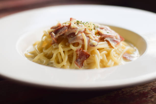 Spaghetti Carbonara in white dish on wood table