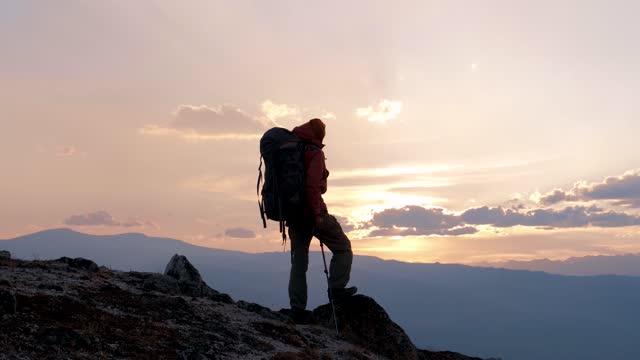 Silhouette Hiker With Backpack On Top Of Mountain Enjoying Landscape At Sunset
