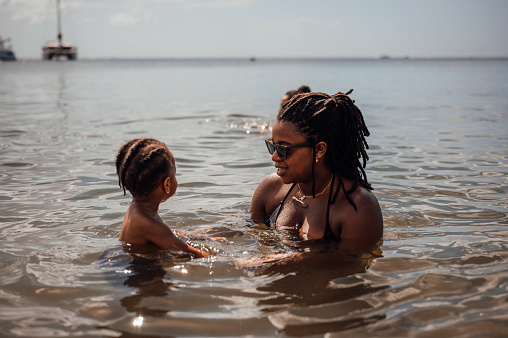 A young family play in the water at the beach