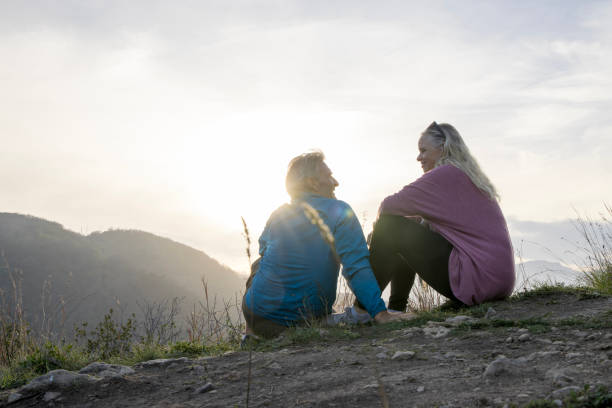istock Mature hiking couple relax at viewpoint in hilly setting 1477795437
