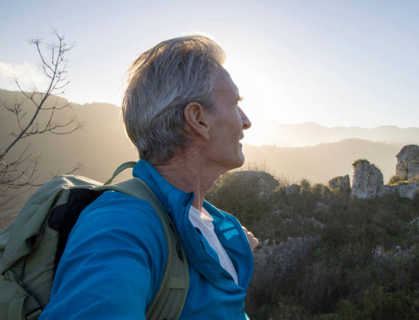 istock Mature male hiker arrives at summit viewpoint in hilly setting 1477795761