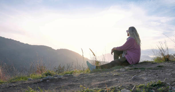 istock Mature female hiker relaxes at viewpoint in hilly setting 1477796547