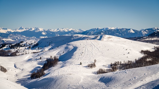 Panoramic view of Austrian ski region of Hintertux Glacier in the region of Tyrol against blue sky with incidental skiers