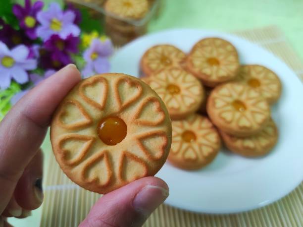 biscotti con marmellata di ananas in mano umana. - human hand baked food pineapple foto e immagini stock