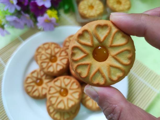 biscotti con marmellata di ananas in mano umana. - human hand baked food pineapple foto e immagini stock