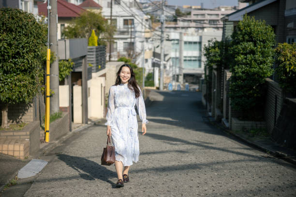 Young woman walking in residential district, looking at camera
