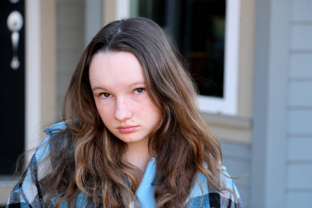 adulto inteligente mirar hermosas chicas adolescente 14 años mira en el marco sin sonrisa contra el telón de fondo de la casa otoño-primavera frío verano fuerte mirada estricta hermosa valiente mujer fuerte - years 13 14 years teenager old fotografías e imágenes de stock