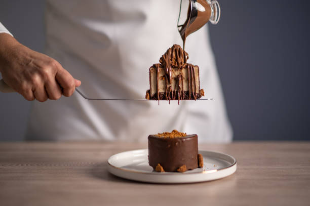 istock Female chef pouring chocolate sauce on cake 1477806375
