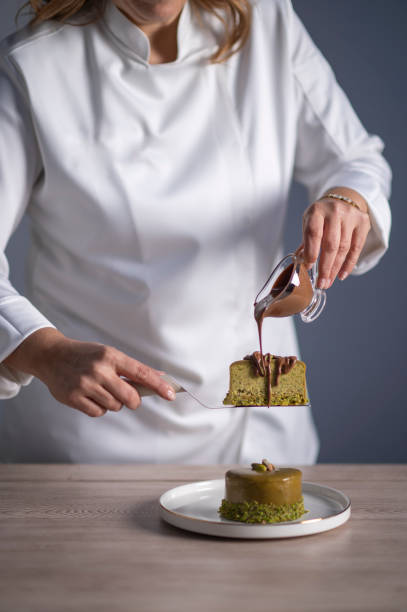 istock Female chef pouring chocolate sauce on cake 1477806444