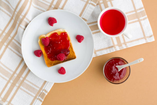 istock Cup of red tea and toasted bread with raspberry jam 1477806776