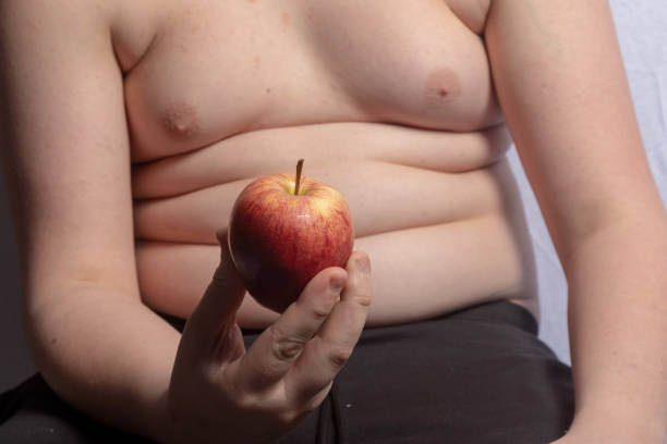istock An overweight teenage boy with an apple 1477809131