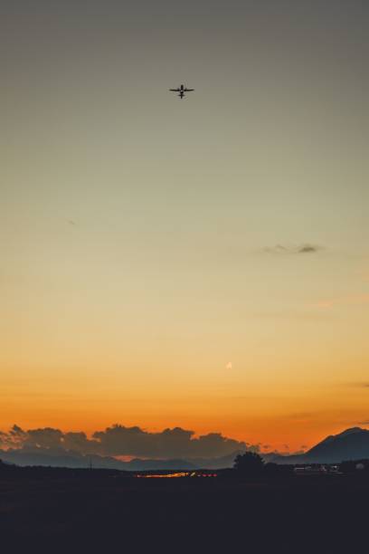 istock Commercial airplane flying over a city during sunset 1477810688