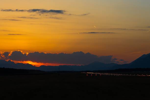 istock Peaceful sunset sky with a few airplanes passing overhead, providing a dramatic contrast 1477810695