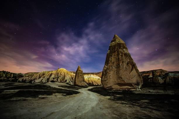 istock Stunning night-time landscape featuring a majestic mountain with a winding road below 1477811299