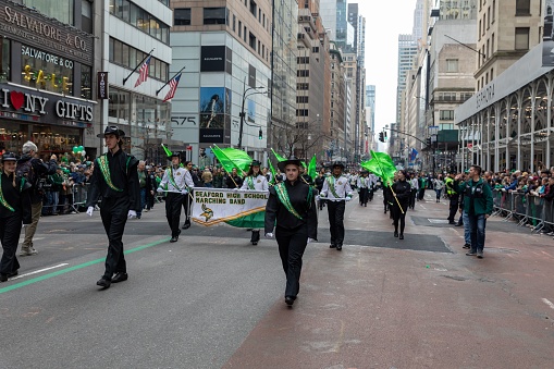 New York City, United States – March 18, 2023: A diverse group of people are gathered together for a festive celebration of Saint Patrick's Day, marching in a vibrant parade