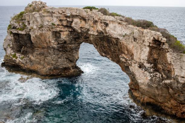 istock a natural arch over the ocean from above with the cliffs and water 1477812069