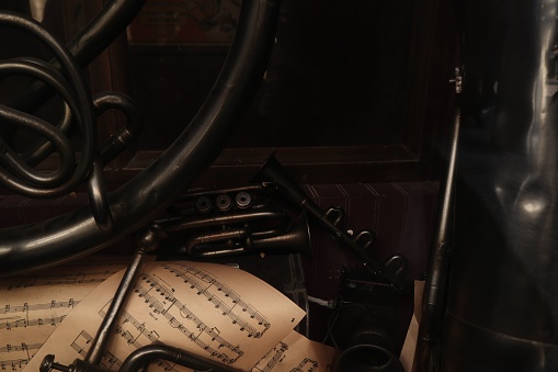 An organized array of sheet music placed on top of a wooden desk, viewed from a slightly elevated angle