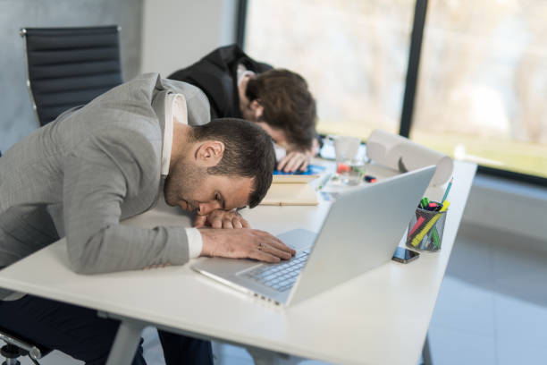 istock Two exhausted businessmen sleeping in the office. 1477813915