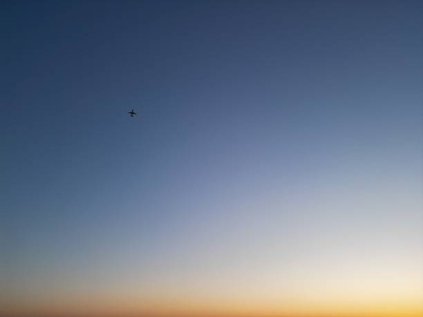 istock Airplane flying in the blue sky at sunset 1477814872