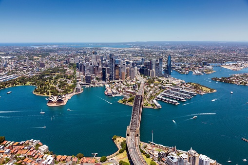 Aerial view of the Sydney skyline, featuring the iconic Sydney Harbour Bridge, towering high above the cityscape